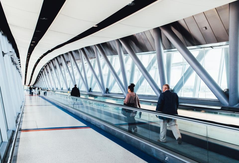 A traveler walking through an airport corridor