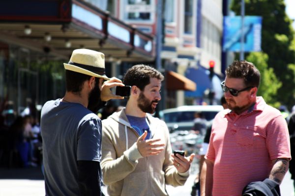 Three friends talking on a sunny city street