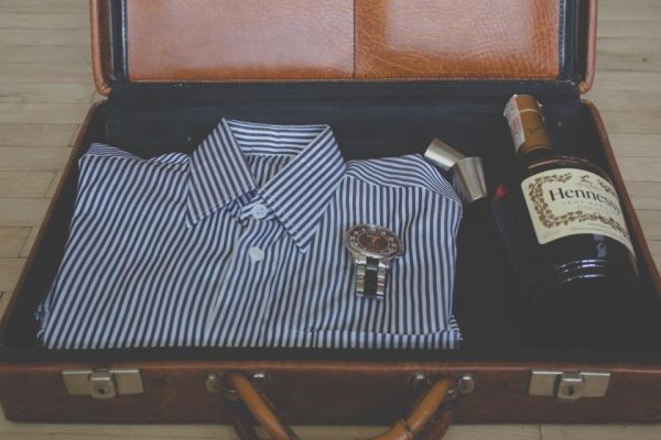 Una valigia aperta con dentro una camicia a righe piegata