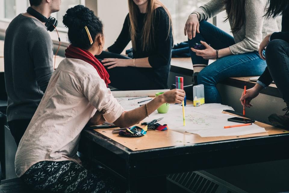 A group of people studying and talking together around a table