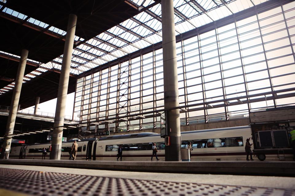 A train waiting under the glass roof of a large station
