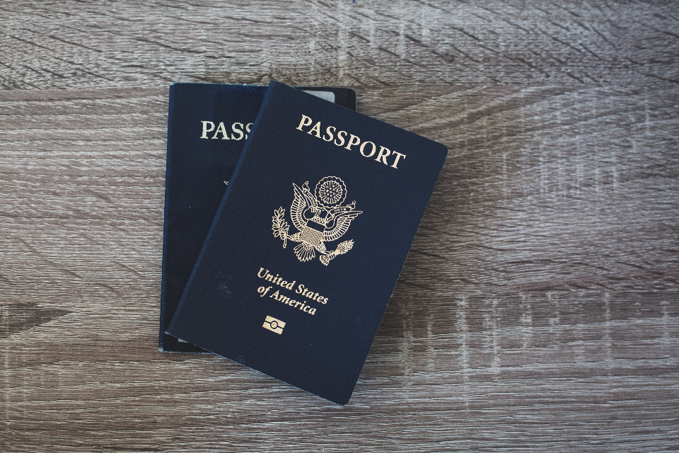 Due passaporti blu degli Stati Uniti appoggiati su un tavolo di legno