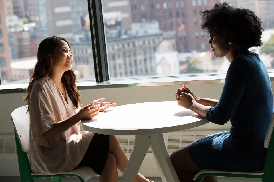 Two people talking across a table